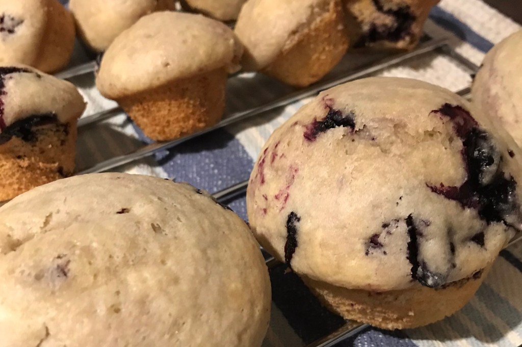 Berry muffins sitting on a cooling rack.